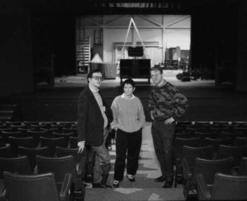Three members of the student standing in front of stage