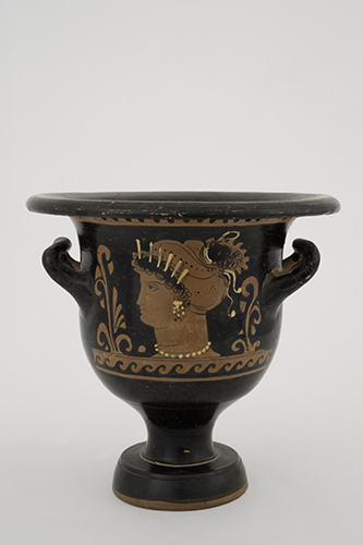 Red-figure bell krater with scene of female head, head of horned male on reverse