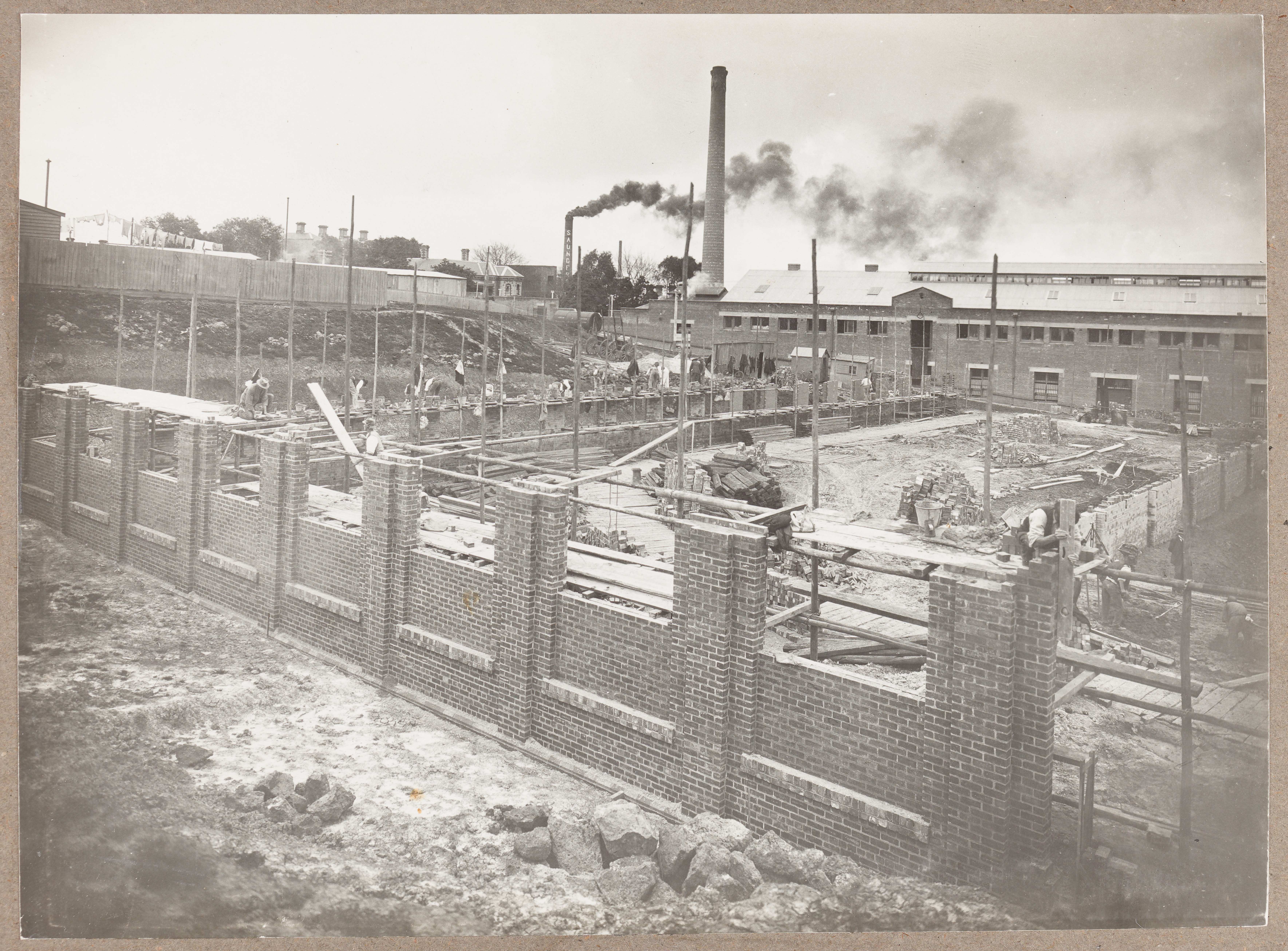 Black and white photograph of factory under construction.