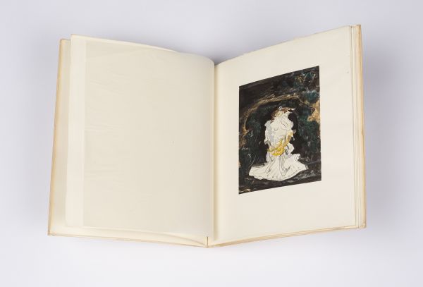 Open faced aged book featuring coloured print on one page.