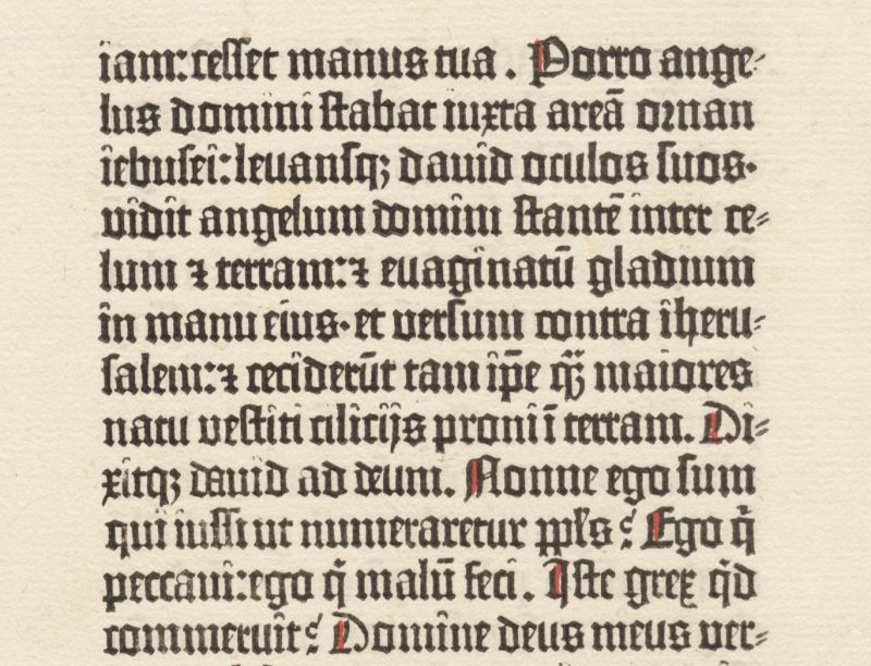 Leaf of very old early printed book with black writing and red accents on aged paper