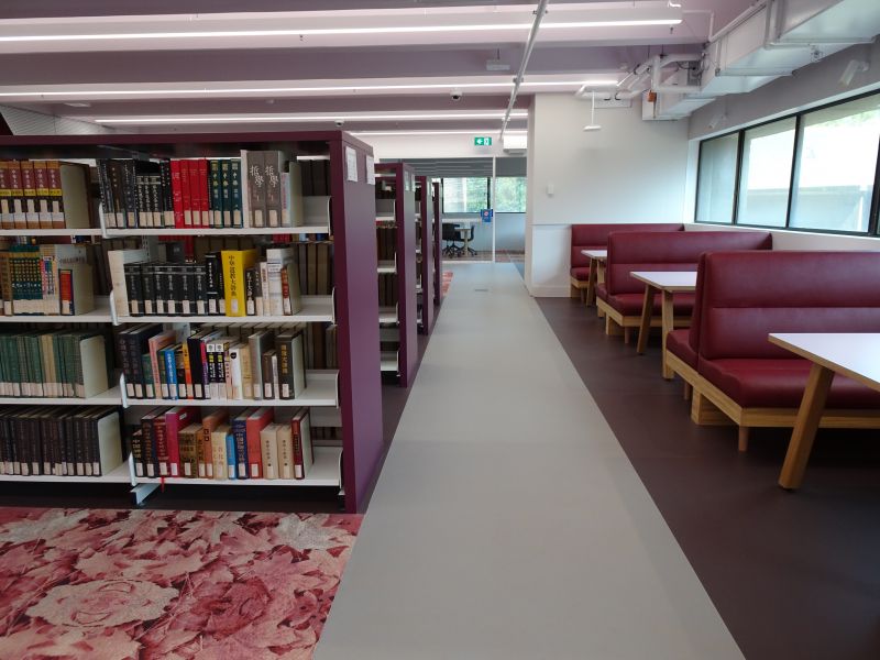 Photograph of a library space with shelves of books and red booth seating